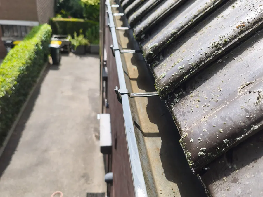 Corniche vidée et rincée le long d'une toiture en tuiles, Villers-l'Évêque